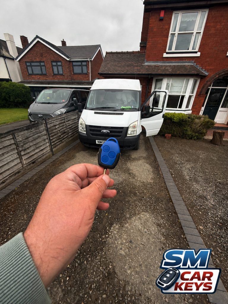 Blue replacement Ford Transit remote key held in front of a white Ford Transit after on-site key programming by SM Car Keys.