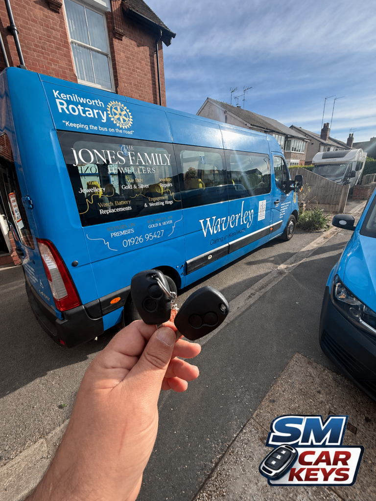 Additional Renault Master key held in front of a blue Renault Master van belonging to Waverley Care in Kenilworth after key cutting by SM Car Keys.