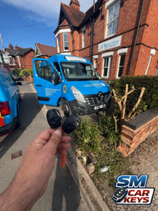 Two Renault Master keys held in front of a blue Renault Master van for Waverley Care in Kenilworth after spare key service by SM Car Keys.